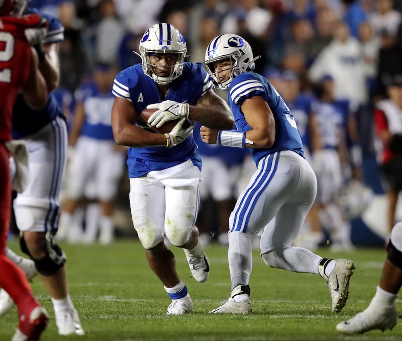 BYU running back Tyler Allgeier takes handoff from quarterback Jaren Hall as BYU and Utah play at LaVell Edwards Stadium.