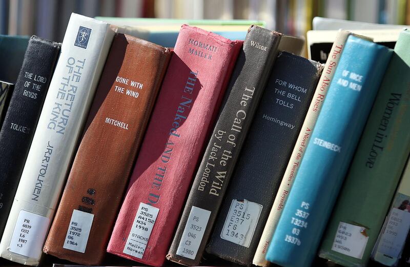 Books that were once banned are stacked together during a Banned Books Open Reading outside the University of Utah’s Marriott Library in Salt Lake City on Monday, Sept. 26, 2016. Illinois Gov. J.B. Pritzker on Monday signed into law a bill that outlaws book bans in the state.