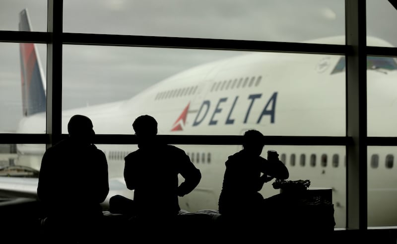 Travelers on Delta Air Lines wait for flights in Detroit on Monday, Oct. 29, 2012.