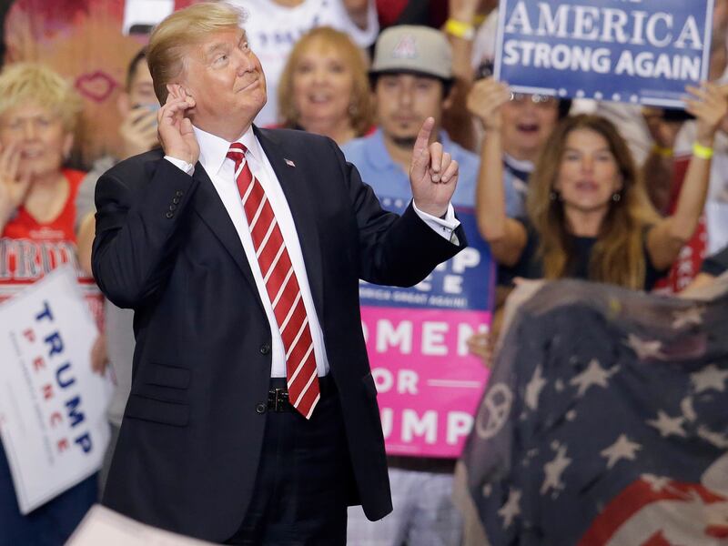 President Donald Trump gestures to the crowd while speaking at a rally at the Phoenix Convention Center, Tuesday, Aug. 22, 2017, in Phoenix.