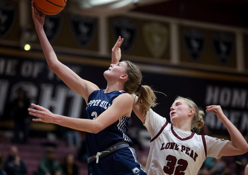 Copper Hills’ Ellie Taylor scores in the last minute of a girls basketball game against Lone Peak in Highland on Tuesday, Dec. 12, 2023.