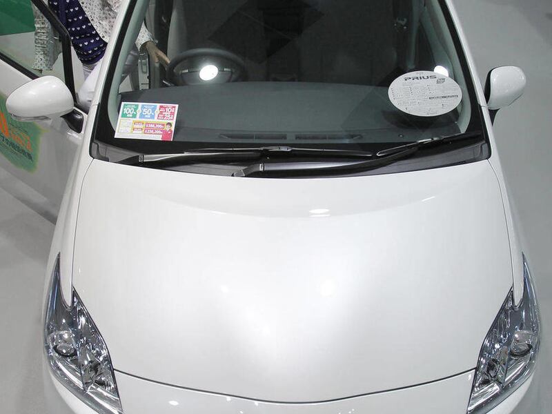 FILE - In this July 6, 2010 file photo, a visitor looks at a 2011 Toyota Prius hybrid vehicle on display at Toyota Motor Corp.'s showroom in Tokyo. Toyota Motor Corp. said Tuesday, March 29, 2010, it wants its U.S. car dealers to stop ordering more than 2