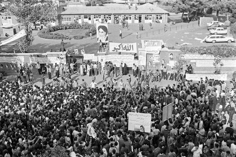 In this Nov. 13, 1979 photo, Iranians pray and gather in front of the American Embassy in Tehran, Iran, where Islamic revolutionary students had been holding 60 American employees hostage since Nov. 4, 1979. Former Iranian hostages had varied reactions to