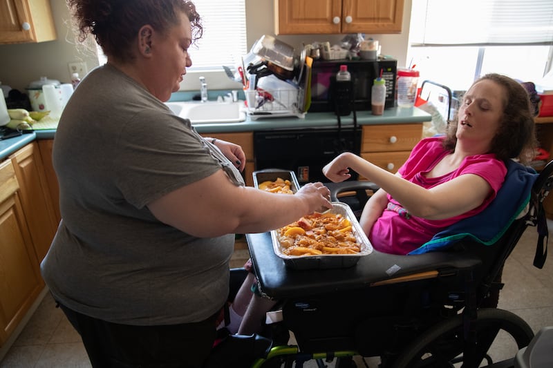 Kira Volar cares for her sister Tara, right, Saturday, August 4, 2018, in their home outside Sacramento, Calif. Kira is a 47-year-old full-time caregiver to her sister, who is paralyzed and has an intellectual disability. Kira has made caregiving her life