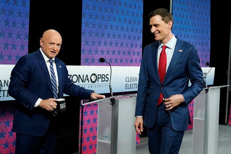 Arizona Democratic Sen. Mark Kelly, left, and his Republican challenger Blake Masters, right, arrive on stage for a debate.