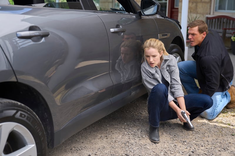 Willa Fitzgerald as “Roscoe Conklin” and Alan Ritchson as “Jack Reacher” duck behind a car in the new Prime Video series, “Reacher.”