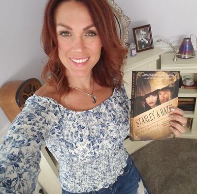 Jo Schaffer holding a copy of the first book in her "Stanley & Hazel" series.