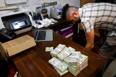 FILE - In this June 27, 2017, photo, bundles of $20 bills are placed on a table as Jerred Kiloh, owner of the Higher Path medical marijuana dispensary, prepares a trip to Los Angeles City Hall to pay his monthly tax payment in cash in Los Angeles.