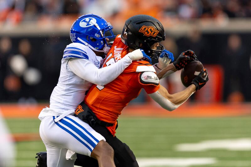 BYU cornerback Kamden Garrett (7) guards Oklahoma State wide receiver Leon Johnson III (17) battles for the ball during game Saturday, Nov. 25, 2023, in Stillwater, Okla.