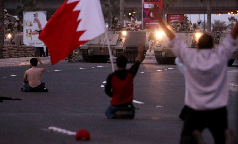 Bahraini protesters face off against army tanks near the Pearl roundabout Friday, Feb. 18, 2011, in Manama, Bahrain. Many protesters began to pray and shouted "peaceful, peaceful". Soldiers fired tear gas and shot heavy weapons into the air as thousands