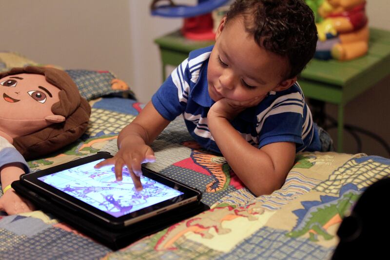 In this Friday, Oct. 21, 2011 photo, Frankie Thevenot, 3, plays with an iPad in his bedroom at his home in Metairie, La.