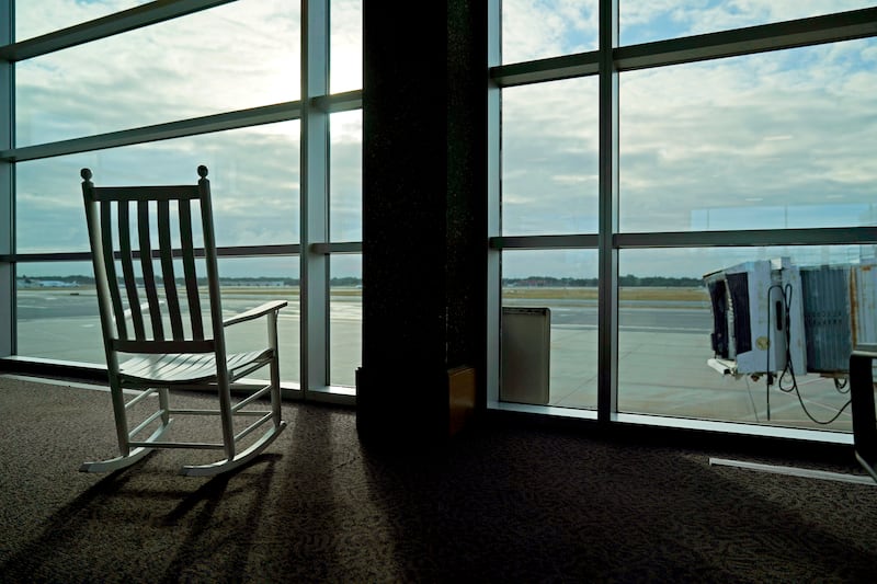 A rocking chair sits empty next to an unused jetway at T.F. Green Airport, in Warwick, R.I., Monday, Aug. 17, 2020.