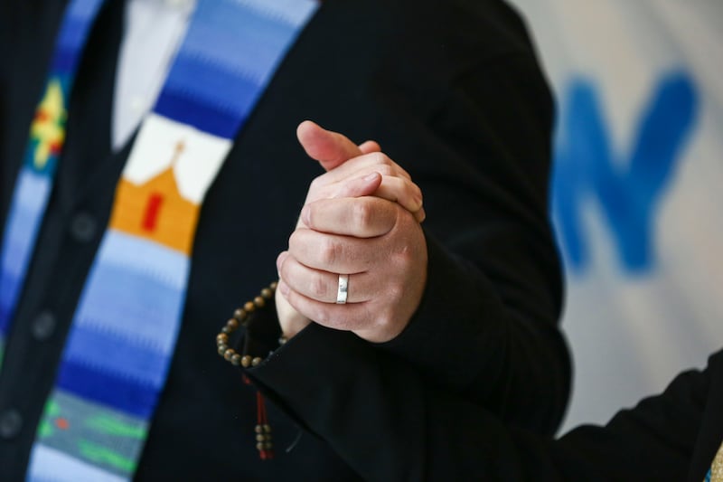 The Rev. Curtis Price holds hands and prays with the Rev. Monica Dobbins in front of the House chambers at the Capitol in Salt Lake City.