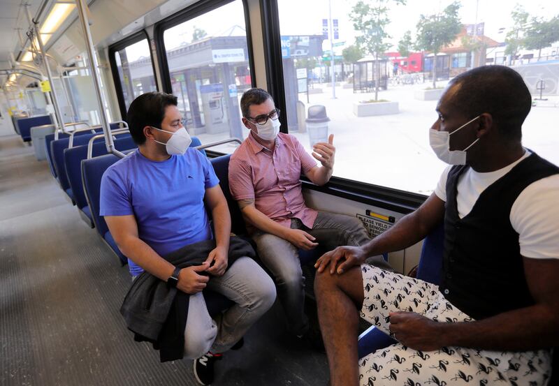 Tiberio Barros, Marcelo Vasconcelos and Gomans Marcus wear masks while waiting for their TRAX train to depart the Salt Lake Central Station in Salt Lake City on Wednesday, July 1, 2020. The Utah Transit Authority now requires face masks be worn in order to ride public transit in compliance with the Salt Lake County health order.