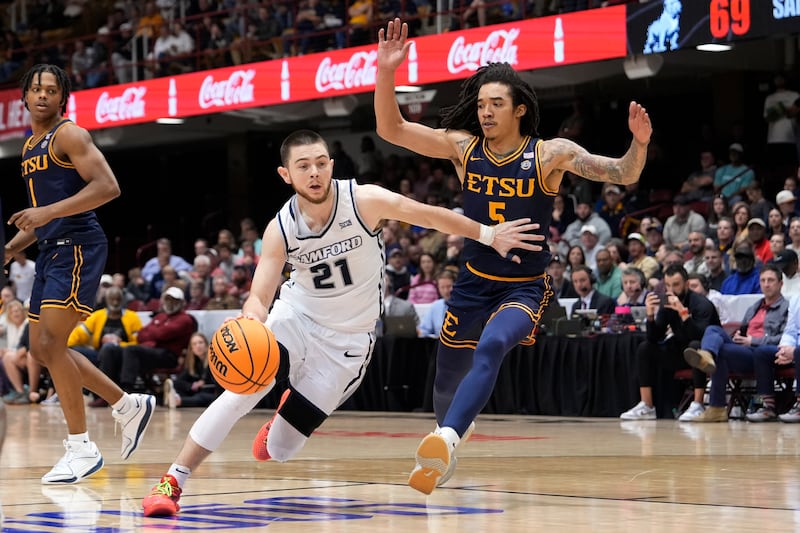 Samford guard Rylan Jones (21) drives the ball against East Tennessee State guard Allen Strothers (5) during the second half of the NCAA college basketball championship game for the Southern Conference tournament, Monday, March 11, 2024, in Asheville, N.C.