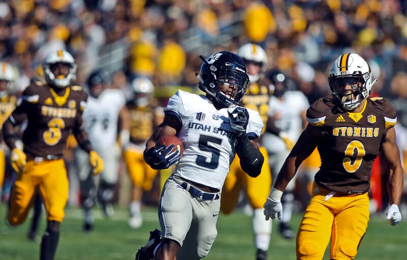 Utah State running back Darwin Thompson (5) runs past Wyoming linebacker Tyler Hall (9) during the first half of an NCAA college football game in Laramie, Wyo., Saturday, Oct. 20, 2018. (Shannon Broderick/Laramie Boomerang via AP)
