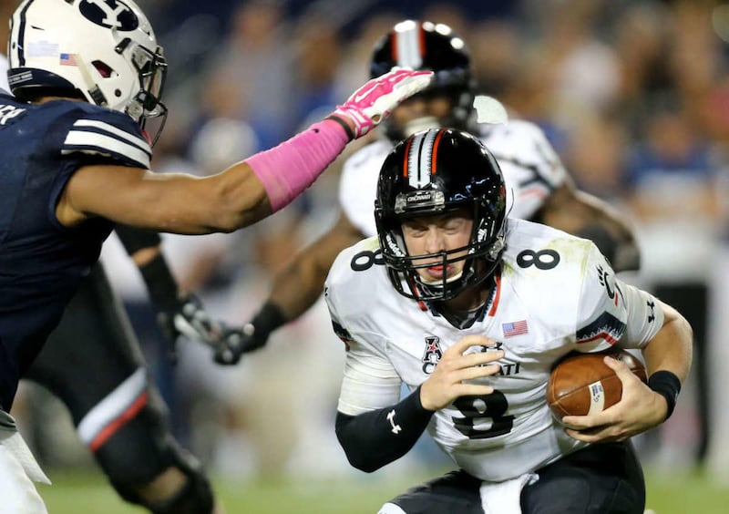 Cincinnati Bearcats quarterback Hayden Moore (8) gets tackled by Brigham Young Cougars linebacker Fred Warner (4) during a football game against BYU at the LaVell Edwards Stadium in Provo Friday, Oct. 16, 2015. BYU won 38-24.