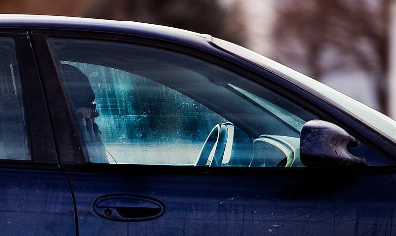 A driver holds his cellphone up to his ear as he drives on State Street in Salt Lake City on Monday, Feb. 25, 2019.