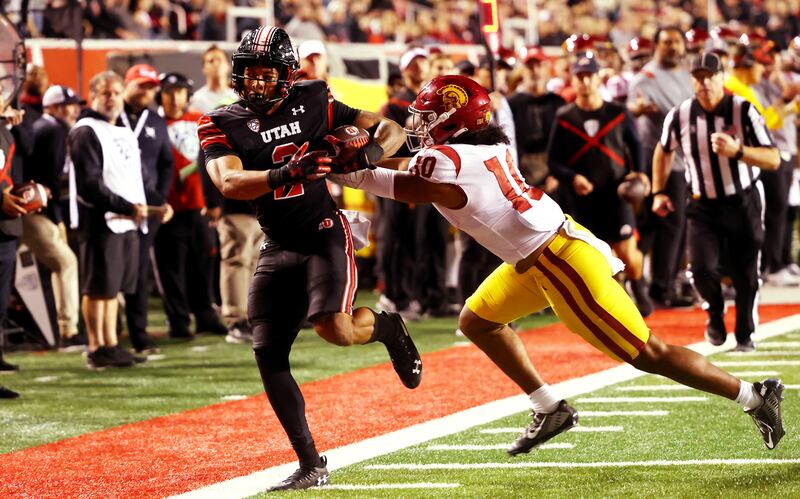 Utah Utes running back Micah Bernard is shoved out of bounds by USC Trojans linebacker Ralen Goforth as Utah and USC play.