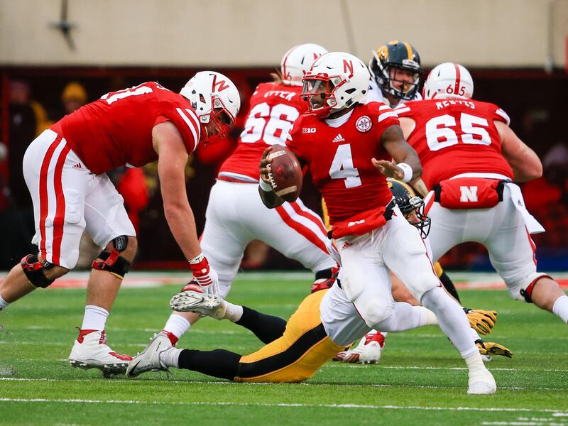 Nebraska quarterback Tommy Armstrong Jr. (4) rolls out of the pocket in front of Iowa linebacker Bo Bower (41) during the first half of an NCAA college football game against Iowa in Lincoln, Neb., Friday, Nov. 27, 2015. The Cornhuskers are one of seven te