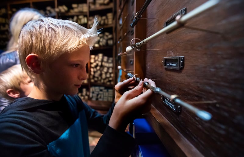 Braxton Truett eyes a wand as he and his mom Christy Truett and little brother Beckam shop at the new Christmas in the Wizarding World at the Shops at South Town in Sandy on Wednesday, Nov. 7, 2018.
