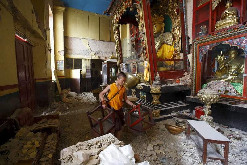 A monk carrying chairs walks out from the damaged monastery at Swoyambhunath Stupa, a UNESCO world heritage site, after Saturday's earthquake in Kathmandu, Nepal on April 28, 2015.