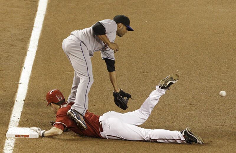 Fernando Tatis, top, waits for the ball as Arizona Diamondbacks' Trent Oeltjen slides into third.
