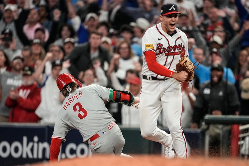 Atlanta Braves first baseman Matt Olson (28) reacts to getting the final out by forcing out Philadelphia Phillies’ Bryce Harper (3) on a fly ball on Oct. 9, 2023