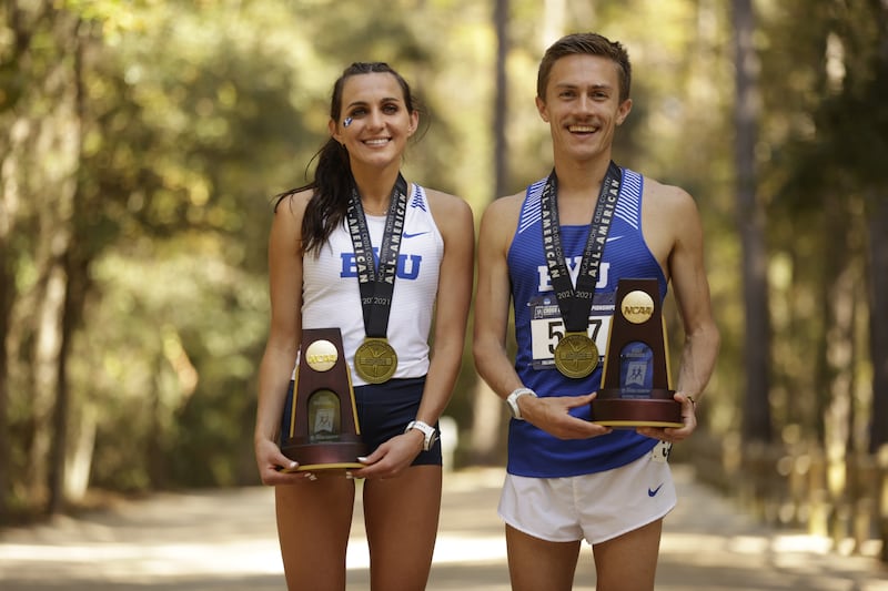 Whittni Orton and Conner Mantz hold their trophies after winning NCAA cross country individual titles on Saturday, Nov. 20, 2021 in Tallahassee, Fla.