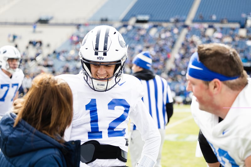 BYU Cougars quarterback Jake Retzlaff laughs with a trainer during the annual BYU Blue vs. White scrimmage.