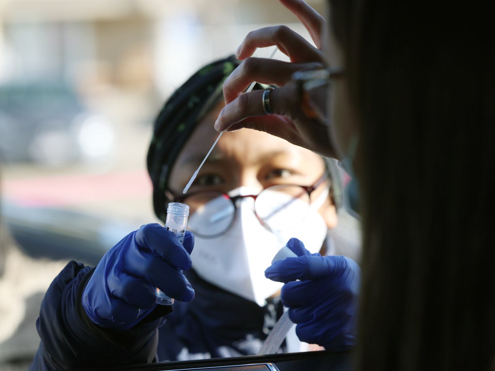Caiden Bishop places her COVID-19 swab into a vial.