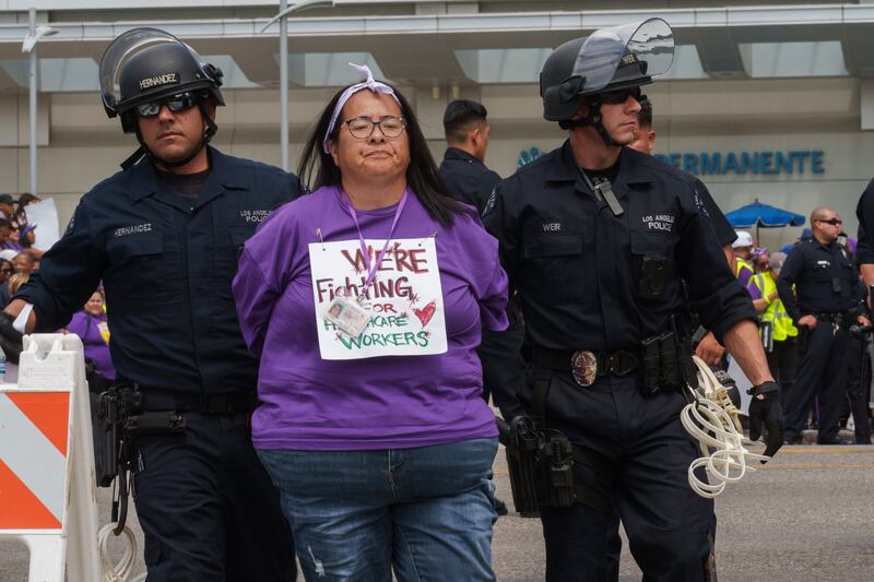A health care worker participates in a civil disobedience demonstration outside Kaiser Permanente Los Angeles Medical Center on Sept. 4, 2023.