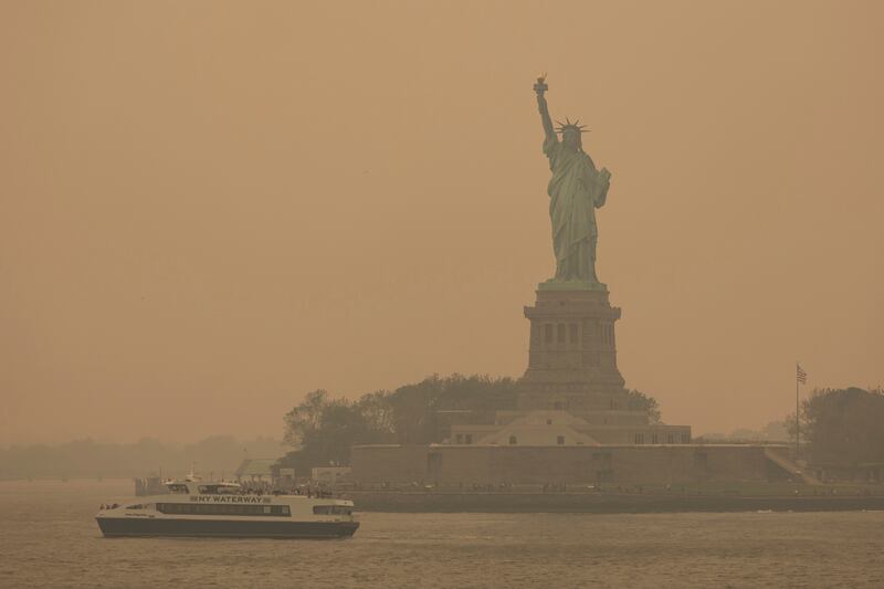 The Statue of Liberty, covered in a haze-filled sky, is photographed from the Staten Island Ferry on June 7, 2023, in New York.
