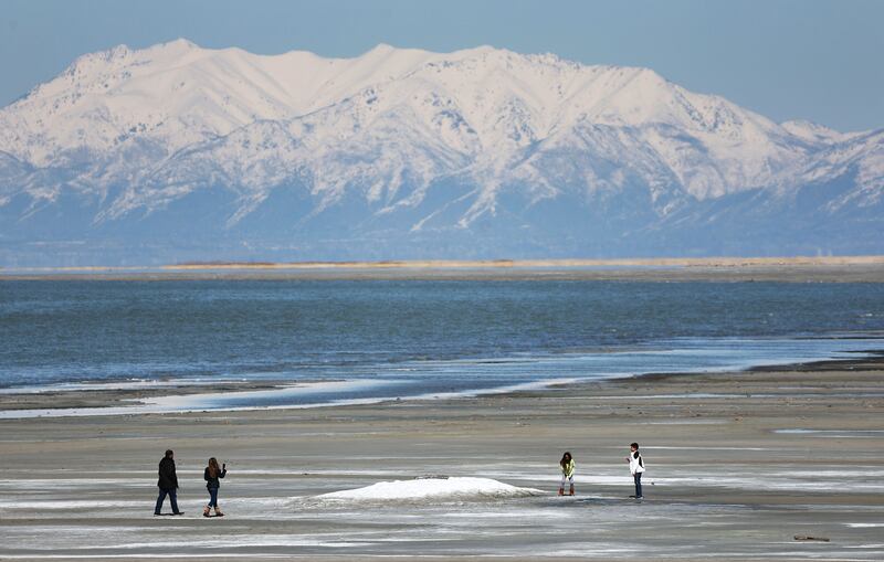People walk on the beach of the Great Salt Lake in Salt Lake City on March 17, 2023.