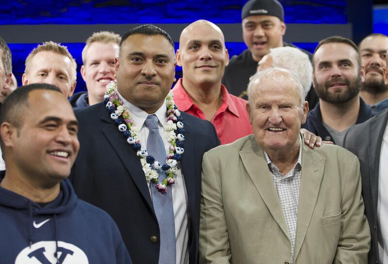 Former players and former head coach LaVell Edwards pose for photos with new head coach Kalani Sitake, following a press conference in Provo Monday, Dec. 21, 2015.
