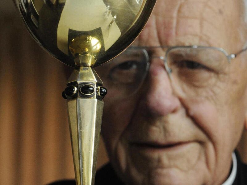 Father Jerry Bruggeman poses in his Colorado Springs, Colo. home Monday, Dec. 13, 2010, with the stolen chalice that recently was returned to him by a man who bought it at an antique store.