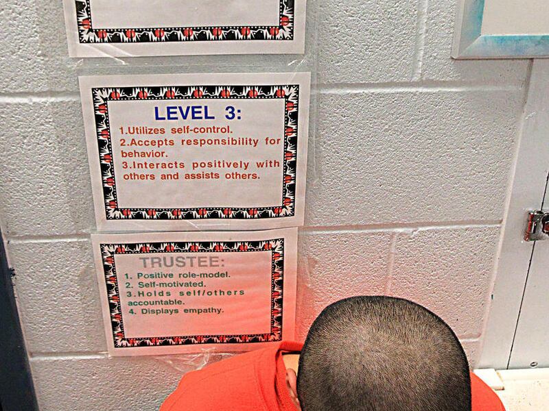 An inmate sits outside an office at the Victoria Regional Juvenile Justice Center in Victoria, Texas on Feb. 21, 2012. Inmates at the Victoria Regional Juvenile Justice Center are part of a training program with young adults incarcerated.