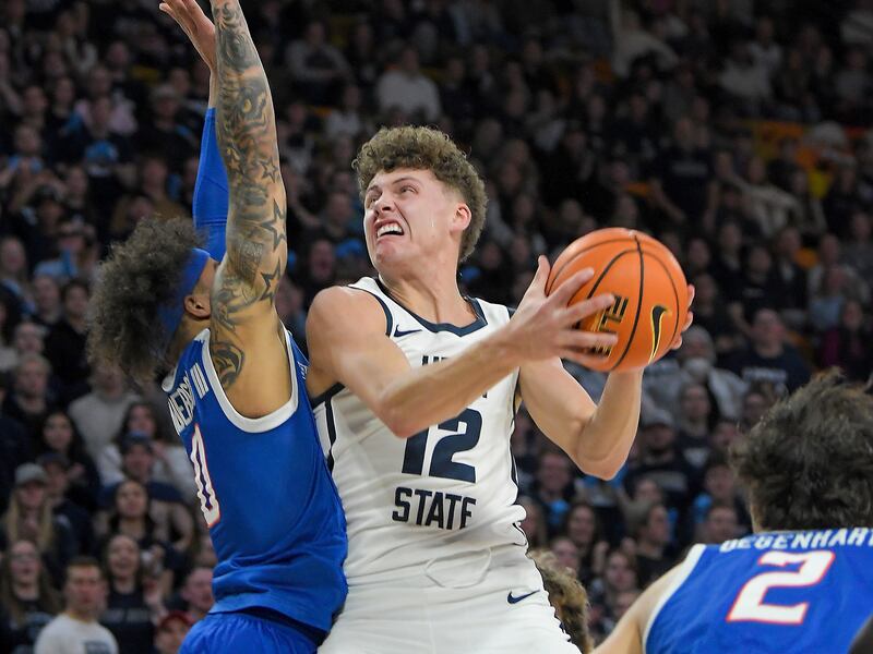 Utah State guard Mason Falslev (12) looks for a shot as Boise State guard Roddie Anderson III (0) defends during the first half of an NCAA college basketball game Saturday, Feb. 10, 2024, in Logan, Utah.