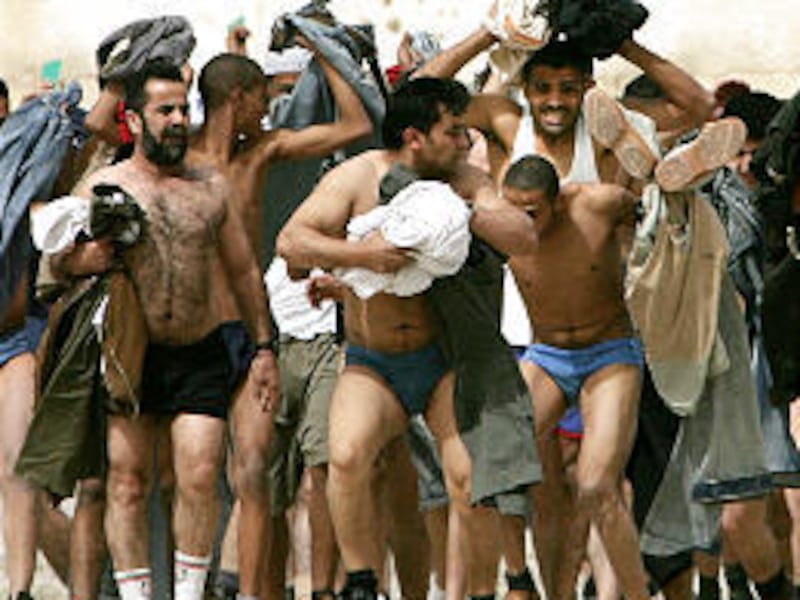 Palestinians, some prisoners, react to gunfire as they leave prison during a raid by Israeli military.