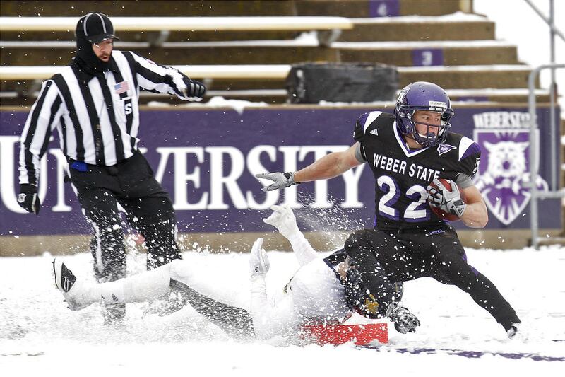 Weber State's C.J. Tuckett (22) is thrown out of bounds short of a touchdown by Northern Arizona's Taylor Malenfant (38) during Coach Mac's final home game on Saturday.