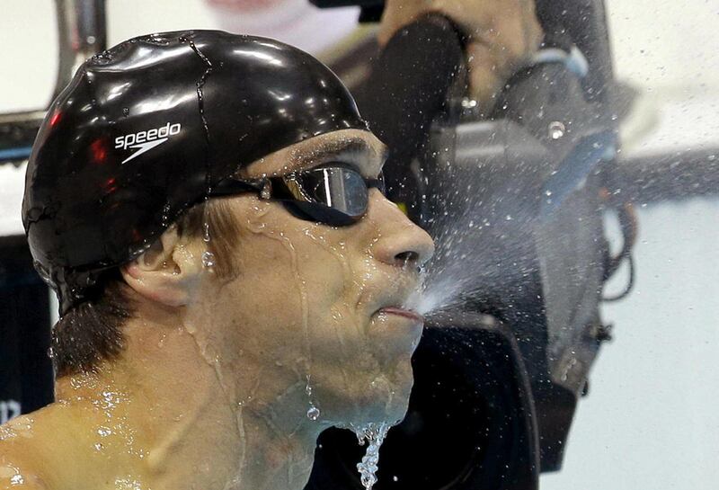 United States' Michael Phelps spits water out of his mouth after winning the men's 100-meter butterfly swimming final at the Aquatics Centre in the Olympic Park during the 2012 Summer Olympics in London, Friday, Aug. 3, 2012.