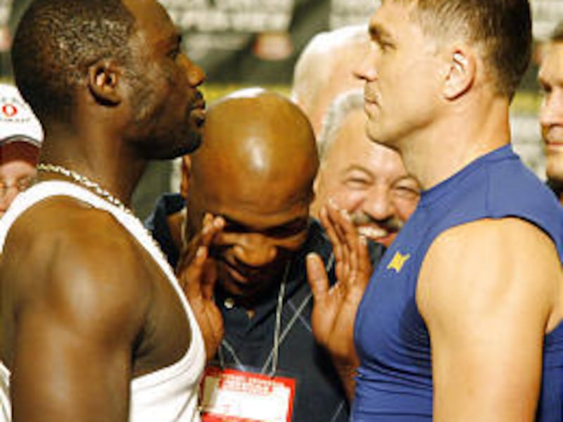 Hasim Rahman, left, and Oleg Maskaev, right, are separated at weigh-in by former heavyweight champ Mike Tyson, center.