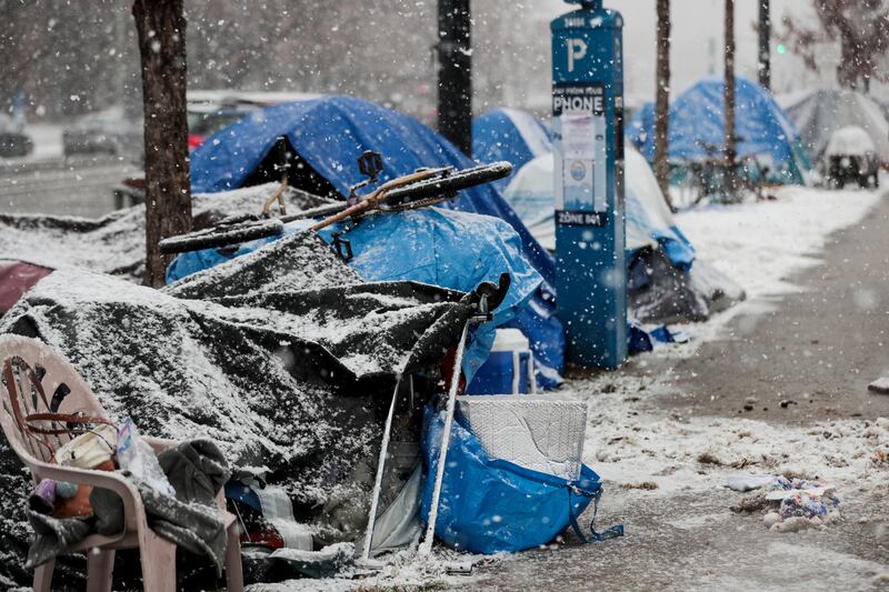 Snow falls on tents where people who are homeless camp along 500 South at Library Square in Salt Lake City on Friday, Nov. 29, 2019.