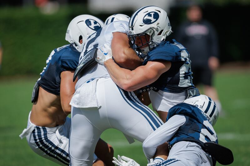 BYU defenders converge on a ball carrier during the Cougars' first full scrimmage Saturday, Aug. 10, 2024, in Provo.