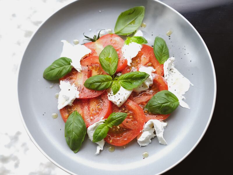 Caprese salad on a gray plate.