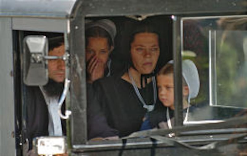A somber Amish family rides in a horse-drawn buggy Thursday in the funeral procession for 7-year-old Naomi Rose Ebersol.