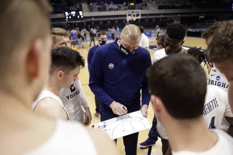 BYU players surround coach Mark Pope during a timeout.