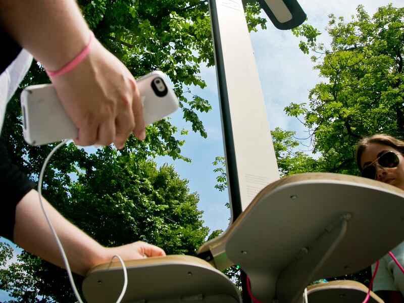 Users check their phones after solar charging the devices in New York.