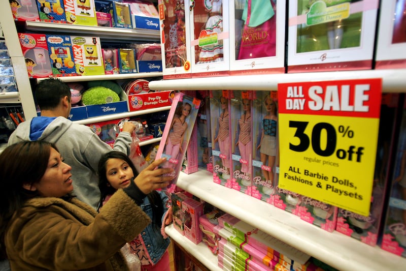 Nery Us, left, buys a new Barbie on sale for her daughter Esmeralda Gomez, center, shortly after 5:00 a.m. on Black Friday at a KB Toys store in Los Angeles, Friday, Nov. 24, 2006. Black Friday marks the traditional start of the holiday shopping season. (
