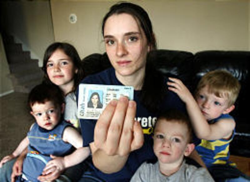 Anndorie Sachs holds her driver's license next to her four children, Derek, 2, Sierra, 6, Tyson, 2, and Skylar, 3. She says her ID cards were stolen from her car in February.